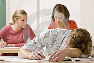 Student sleeping at desk in classroom