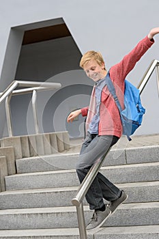 Student sliding down railing on stairway