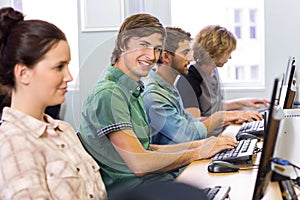 Student smiling at camera in computer class