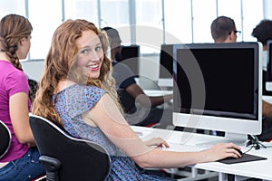 Student smiling at camera in computer class