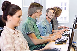 Student smiling at camera in computer class