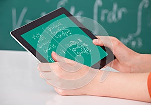 Student solving math's problem on digital tablet in classroom