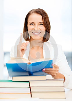 Student with stack pile of books