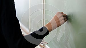 Student standing at the blackboard writing with chalk