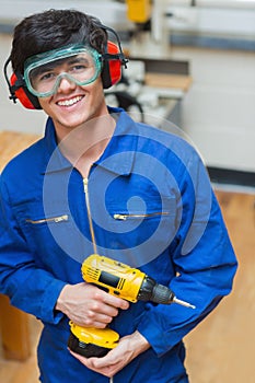 Student standing while holding a driller