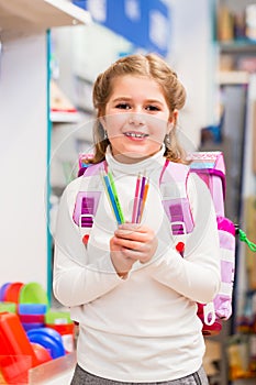 Student in stationery store buying pens