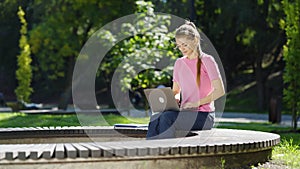 Student studying in park using laptop