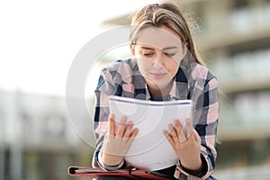Student studying reading notes outdoors