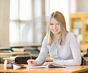 Student with tablet computer in library.