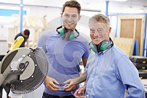 Student And Teacher In Carpentry Class With Circular Saw