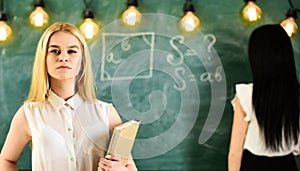 Student, teacher in formal wear stand in classroom. Students and trainees concept. Girl looks confident while lady