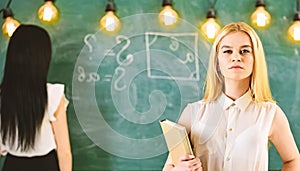 Student, teacher in formal wear stand in classroom. Students and trainees concept. Girl looks confident while lady