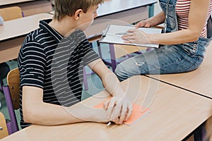 Student and teacher during physics lesson at school