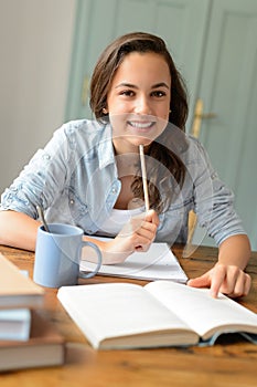 Student teenage girl studying at home smiling