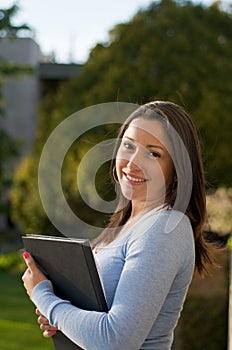 Student with textbook on campus