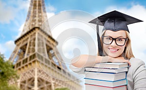 Student in trencher with books over eiffel tower