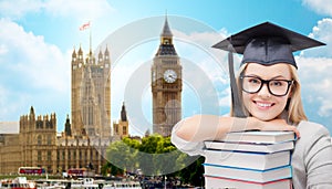 Student in trencher cap with books over london