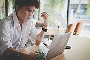 student using computer for learning leasson online at cafe. angry startup man working with laptop at office. young annoyed male