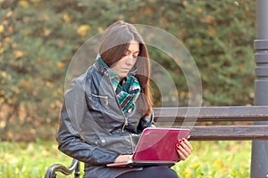 Student using laptop on park bench photo