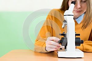 Student using microscope to examine samples in biology class.