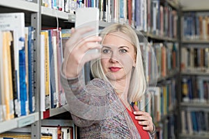 Student Using Mobile Phone for Selfie in Library