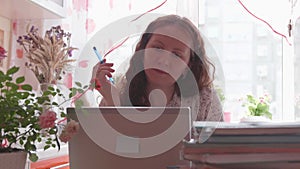 The student watches the lesson online and learns at home. A young girl does her homework while looking at the computer