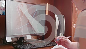 The student watches the lesson online and learns at home. A young girl does her homework while looking at the computer