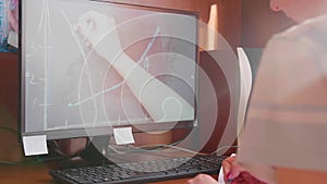 The student watches the lesson online and learns at home. A young girl does her homework while looking at the computer