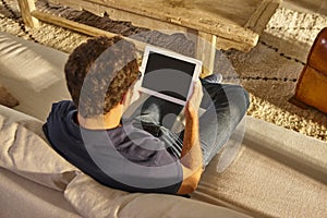 Student watching a tablet on a couch. Social media network