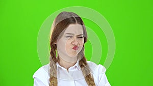 Student in a white blouse and pigtails shows a fist . Green screen