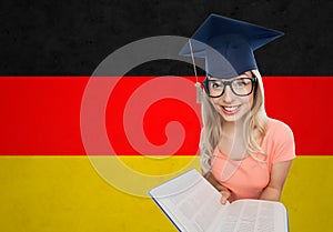 Student woman in mortarboard with encyclopedia