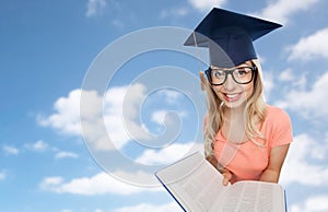 Student woman in mortarboard with encyclopedia