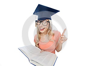 Student woman in mortarboard with encyclopedia