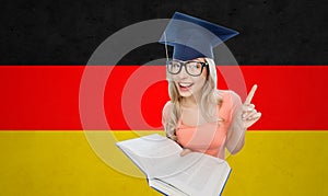 Student woman in mortarboard with encyclopedia