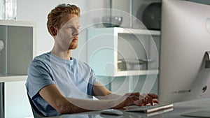 Student working studying home closeup. Confident ginger man writing check email.