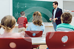 Student working with teacher at the board in front of class