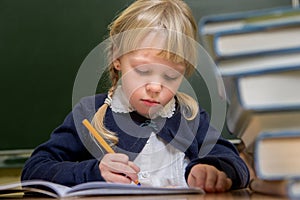 Student works in a school classroom, child at school,