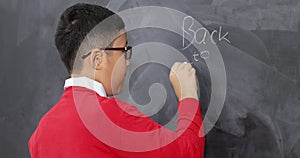 Student writing Back to School text on blackboard