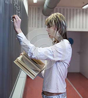 student writing on the blackboard