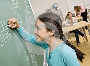 Student writing on blackboard