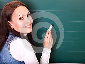 Student writing on blackboard.