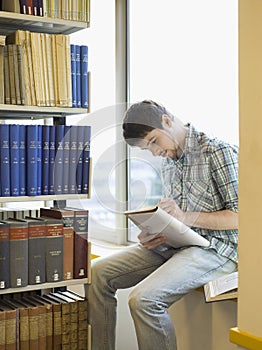 Student Writing Notes On Windowsill In Library