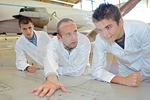 Students in aircraft hangar looking at plan fuselage
