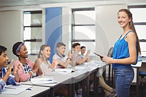 Students appreciating classmate after presentation in classroom