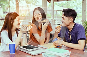 Students asian group together eating pizza in breaking time