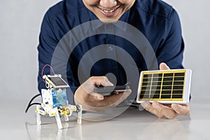 Students build a solar powered robot in their home office by controlling it via smartphone. DIY solar powered robot on a table at
