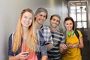 Students with cellphones at college corridor