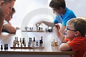 Students, chess and playing in a classroom, conversation and thinking with solution, problem solving and competition