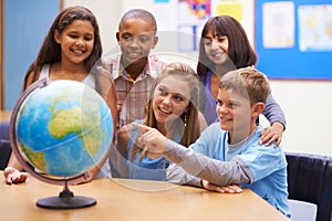 Students, children with globe and learning map in classroom for education, teaching and quiz or group support. Happy