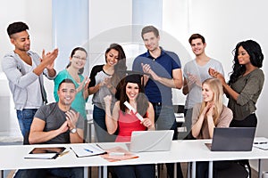 Students Clapping For Classmate Holding Degree